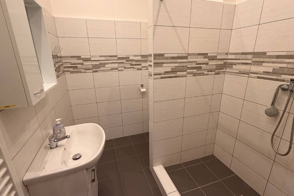 Apartmán č. 2 — koupelna se sprchovým koutem a umyvadlem
